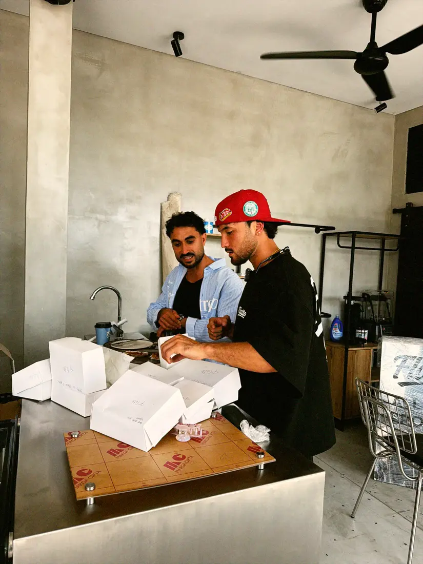 Two of the team boxing up bakery at the steel counter